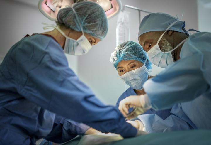 Three surgeons under surgery lights